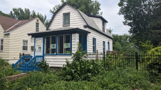 my small house in north Minneapolis, with white siding and now bright turquoise window frames