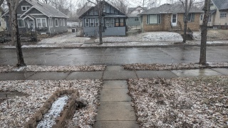 snow in front yard of north Minneapolis home, 2024 February 14, snow barely covering most of the ground, still melting from sidewalks and street